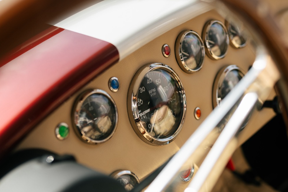 Close detail of the tan dashboard gauges of a classic roadster