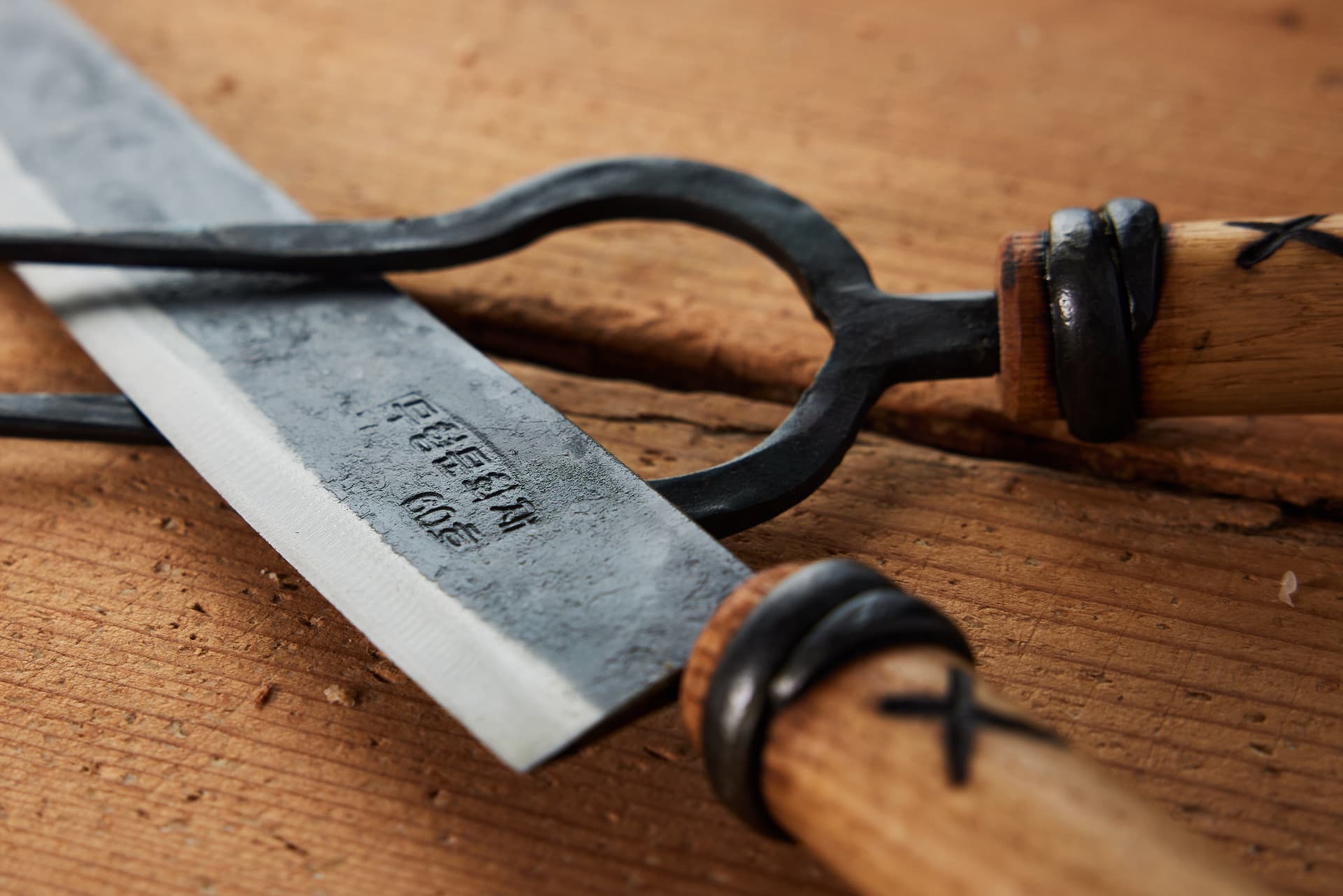 Close detail of a forged blade stamp and oak handles